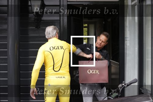 Purmerend 16 mei 2020
Dries Roelvink brengt op de fiets in een gele wielrentrui/broek een pakketje van OGER naar Danny de Munk die thuyis de deur opent als dries aan belt .