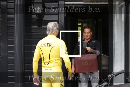 Purmerend 16 mei 2020
Dries Roelvink brengt op de fiets in een gele wielrentrui/broek een pakketje van OGER naar Danny de Munk die thuyis de deur opent als dries aan belt .