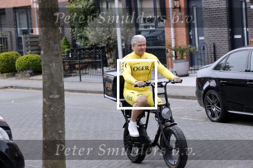 Purmerend 16 mei 2020
Dries Roelvink brengt op de fiets in een gele wielrentrui/broek een pakketje van OGER naar Danny de Munk die thuyis de deur opent als dries aan belt .