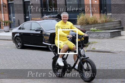 Purmerend 16 mei 2020
Dries Roelvink brengt op de fiets in een gele wielrentrui/broek een pakketje van OGER naar Danny de Munk die thuyis de deur opent als dries aan belt .