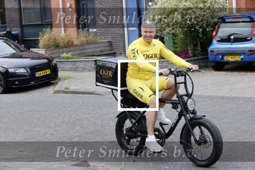 Purmerend 16 mei 2020
Dries Roelvink brengt op de fiets in een gele wielrentrui/broek een pakketje van OGER naar Danny de Munk die thuyis de deur opent als dries aan belt .