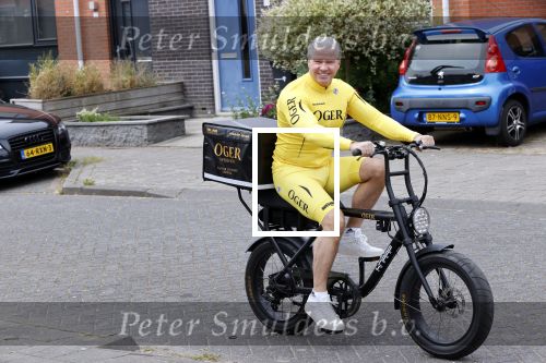 Purmerend 16 mei 2020
Dries Roelvink brengt op de fiets in een gele wielrentrui/broek een pakketje van OGER naar Danny de Munk die thuyis de deur opent als dries aan belt .