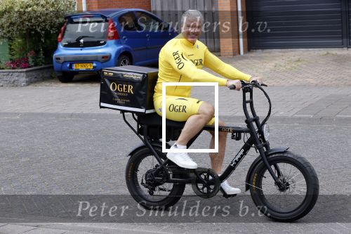 Purmerend 16 mei 2020
Dries Roelvink brengt op de fiets in een gele wielrentrui/broek een pakketje van OGER naar Danny de Munk die thuyis de deur opent als dries aan belt .