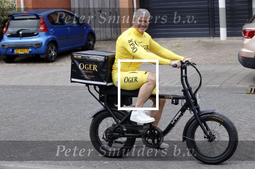 Purmerend 16 mei 2020
Dries Roelvink brengt op de fiets in een gele wielrentrui/broek een pakketje van OGER naar Danny de Munk die thuyis de deur opent als dries aan belt .