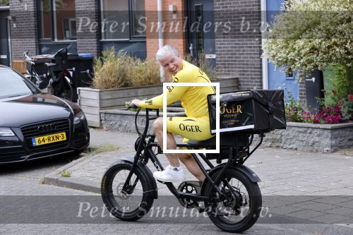 Purmerend 16 mei 2020
Dries Roelvink brengt op de fiets in een gele wielrentrui/broek een pakketje van OGER naar Danny de Munk die thuyis de deur opent als dries aan belt .
