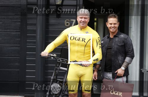 Purmerend 16 mei 2020
Dries Roelvink brengt op de fiets in een gele wielrentrui/broek een pakketje van OGER naar Danny de Munk die thuyis de deur opent als dries aan belt .