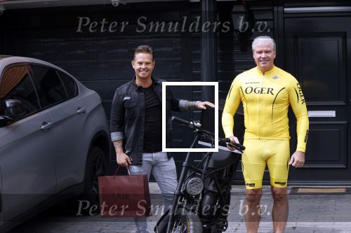 Purmerend 16 mei 2020
Dries Roelvink brengt op de fiets in een gele wielrentrui/broek een pakketje van OGER naar Danny de Munk die thuyis de deur opent als dries aan belt .