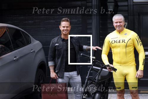 Purmerend 16 mei 2020
Dries Roelvink brengt op de fiets in een gele wielrentrui/broek een pakketje van OGER naar Danny de Munk die thuyis de deur opent als dries aan belt .