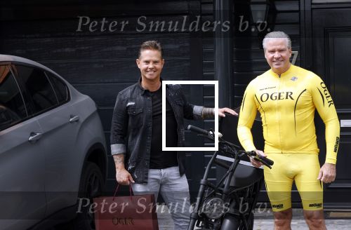 Purmerend 16 mei 2020
Dries Roelvink brengt op de fiets in een gele wielrentrui/broek een pakketje van OGER naar Danny de Munk die thuyis de deur opent als dries aan belt .