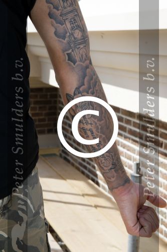 Amsterdam 15 april 2015
Dave en Dries Roelvink metselen een steen met daarop hun naam in de Westertoren. Dave heeft een tatoo van de westertoren op zijn arm staan.