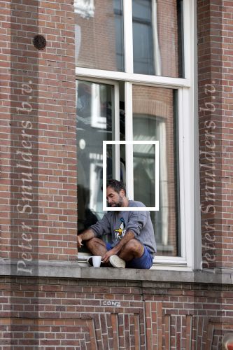 Amsterdam 17 mei 2021
Man zit buiten op zijn vensterbank sigaretje te roken