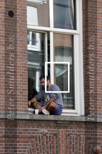 Amsterdam 17 mei 2021
Man zit buiten op zijn vensterbank sigaretje te roken