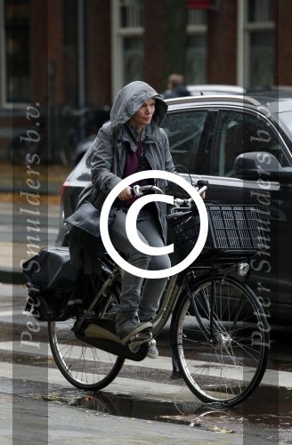 Amsterdam 7 november 2015 
Renee Soutendijk in regenpak op de fiets
