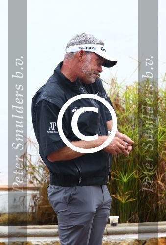 Vilamoura 10-11-12 Oktober 2014
Portugal Masters op GC Victoria
Vanwege de zware regenval gereduceerd van 72 naar 36 Holes
Darren Clark met mobiele telefoon en sigaret
Foto Peter Smulders BV