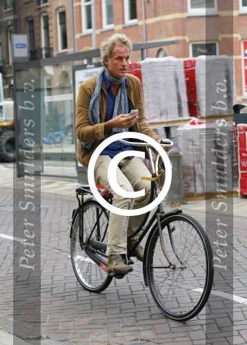 Amsterdam 23 september 2014
Jeroen Pauw op de fiets in Amsterdam zuid continu kijkend op zijn mobiel.