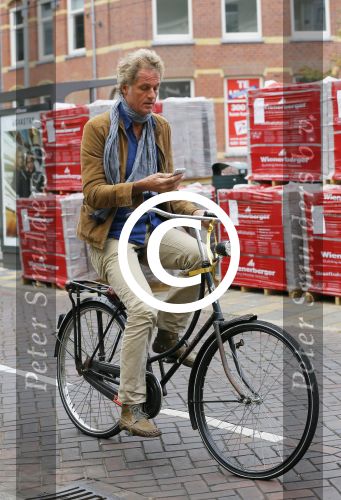 Amsterdam 23 september 2014
Jeroen Pauw op de fiets in Amsterdam zuid continu kijkend op zijn mobiel.