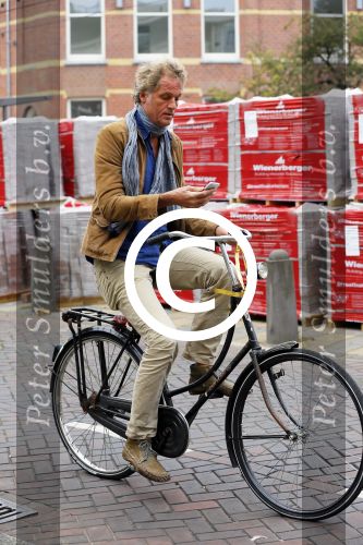 Amsterdam 23 september 2014
Jeroen Pauw op de fiets in Amsterdam zuid continu kijkend op zijn mobiel.