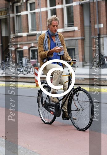 Amsterdam 23 september 2014
Jeroen Pauw op de fiets in Amsterdam zuid continu kijkend op zijn mobiel.