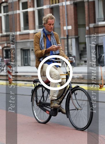 Amsterdam 23 september 2014
Jeroen Pauw op de fiets in Amsterdam zuid continu kijkend op zijn mobiel.