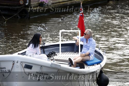 Amsterdam 11 augustus 2024
Jort Kelder en (een) vriendin op zijn sloep op de grachten van Amsterdam op mooie zonnige zondagmiddag . Ze varen naar zijn huis / appartement in omgeving Artis.