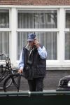 Amsterdam, 19 Juli 2011
Piet Romer msamen met zijn vrouw en hulp voor zijn huis
druk bellend.
Foto Peter Smulders BV