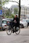Amsterdam 20 juni 2015  
Trijntje Oosterhuis met zoontje op de fiets in Amsterdam. Trijntje gaat een huis binnen en ze geeft een toerist uitleg over hoe waar naartoe te lopen.