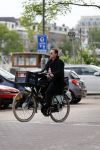 Amsterdam 20 juni 2015  
Trijntje Oosterhuis met zoontje op de fiets in Amsterdam. Trijntje gaat een huis binnen en ze geeft een toerist uitleg over hoe waar naartoe te lopen.