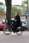 Amsterdam 20 juni 2015  
Trijntje Oosterhuis met zoontje op de fiets in Amsterdam. Trijntje gaat een huis binnen en ze geeft een toerist uitleg over hoe waar naartoe te lopen.