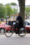 Amsterdam 20 juni 2015  
Trijntje Oosterhuis met zoontje op de fiets in Amsterdam. Trijntje gaat een huis binnen en ze geeft een toerist uitleg over hoe waar naartoe te lopen.
