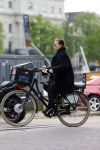 Amsterdam 20 juni 2015  
Trijntje Oosterhuis met zoontje op de fiets in Amsterdam. Trijntje gaat een huis binnen en ze geeft een toerist uitleg over hoe waar naartoe te lopen.