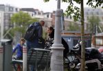 Amsterdam 20 juni 2015  
Trijntje Oosterhuis met zoontje op de fiets in Amsterdam. Trijntje gaat een huis binnen en ze geeft een toerist uitleg over hoe waar naartoe te lopen.