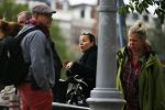 Amsterdam 20 juni 2015  
Trijntje Oosterhuis met zoontje op de fiets in Amsterdam. Trijntje gaat een huis binnen en ze geeft een toerist uitleg over hoe waar naartoe te lopen.