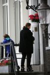 Amsterdam 20 juni 2015  
Trijntje Oosterhuis met zoontje op de fiets in Amsterdam. Trijntje gaat een huis binnen en ze geeft een toerist uitleg over hoe waar naartoe te lopen.