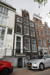 Amsterdam 20 juni 2015  
Trijntje Oosterhuis met zoontje op de fiets in Amsterdam. Trijntje gaat een huis binnen en ze geeft een toerist uitleg over hoe waar naartoe te lopen.