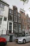 Amsterdam 20 juni 2015  
Trijntje Oosterhuis met zoontje op de fiets in Amsterdam. Trijntje gaat een huis binnen en ze geeft een toerist uitleg over hoe waar naartoe te lopen.