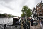 Amsterdam 20 juni 2015  
Trijntje Oosterhuis met zoontje op de fiets in Amsterdam. Trijntje gaat een huis binnen en ze geeft een toerist uitleg over hoe waar naartoe te lopen.