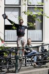 Amsterdam 13 juli 2016  
Selwyn Senatori zit samen met zijn vriendin op bankje zijn boek te signeren als haar fiets omvalt en haarvtas met mobieltje etc het water in valt . Een rondvaartboot vist alles eruit