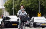 Amsterdam 16 juli 2023
Birgit Schuurman met zoontje op de fiets . Haar vriend Sander v Haarlem rijdt op scooter