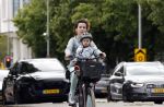 Amsterdam 16 juli 2023
Birgit Schuurman met zoontje op de fiets . Haar vriend Sander v Haarlem rijdt op scooter