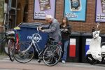Amsterdam 1 juli 2024
Youp van t Hek en zijn vrouw Debby Petter op terras en op de fiets in Amsterdam zuid. Ze zijn beide druk op hun telefoon.