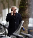 Amsterdam 31 januari 2018 
Tom Egbers bellend op straat met zijn hond