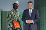 Koninklijke Familie bij uitreiking Prins Claus Prijs 2015 in het Koninklijk Paleis op de Dam. De Prins Claus Prijzen worden door het Prins Claus Fonds voor Cultuur en Ontwikkeling sinds 1997 jaarlijks toegekend aan kunstenaars, denkers en culturele organisaties. 

Royal Family at ceremony Prince Claus Award in 2015 at the Royal Palace on Dam Square. The Prince Claus Awards are presented by the Prince Claus Fund for Culture and Development since 1997 awarded annually to artists, thinkers and cultural organizations.

OP de foto / On the photo:  Laureaat Amakhosi (Zimbabwe, 1980), theater en culturele organisatie