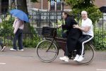 Amsterdam 18 juni 2024
Dries Roelvink achter op de fiets bij zijn vrouw Honoria.