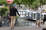 Amsterdam 5 juni 2025
Thijs Romer met petje op laat zijn hond uit in het centrum van Amsterdam.