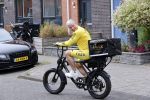 Purmerend 16 mei 2020
Dries Roelvink brengt op de fiets in een gele wielrentrui/broek een pakketje van OGER naar Danny de Munk die thuyis de deur opent als dries aan belt .