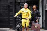Purmerend 16 mei 2020
Dries Roelvink brengt op de fiets in een gele wielrentrui/broek een pakketje van OGER naar Danny de Munk die thuyis de deur opent als dries aan belt .