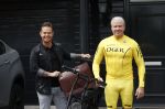 Purmerend 16 mei 2020
Dries Roelvink brengt op de fiets in een gele wielrentrui/broek een pakketje van OGER naar Danny de Munk die thuyis de deur opent als dries aan belt .