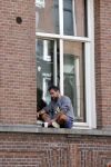 Amsterdam 17 mei 2021
Man zit buiten op zijn vensterbank sigaretje te roken