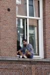 Amsterdam 17 mei 2021
Man zit buiten op zijn vensterbank sigaretje te roken