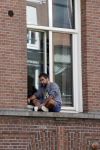 Amsterdam 17 mei 2021
Man zit buiten op zijn vensterbank sigaretje te roken